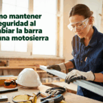 Mujer con gafas de seguridad inspecciona barra de motosierra en taller.
