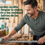 Hombre limpiando la barra de una motosierra con trapo en taller de carpintería.