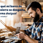 Hombre revisando la barra de una motosierra en su taller.
